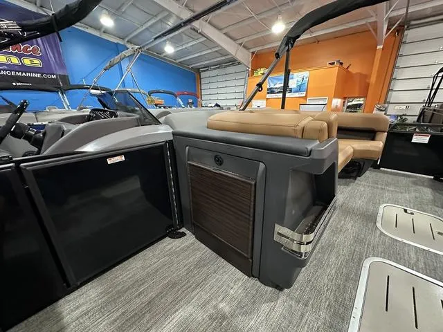 Slide: The Image of 2025 Bennington M Swingback 24 MSB pontoon boat with tan seating in showroom. - 23