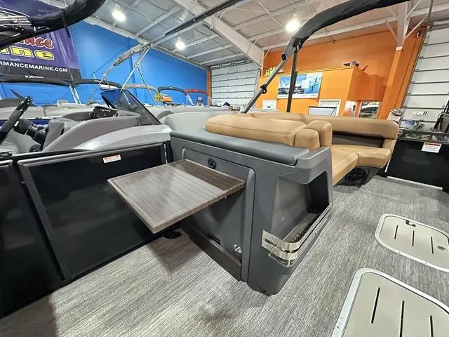 Slide: The Image of 2025 Bennington M Swingback 24 MSB interior with seating and fold-out table in showroom. - 24