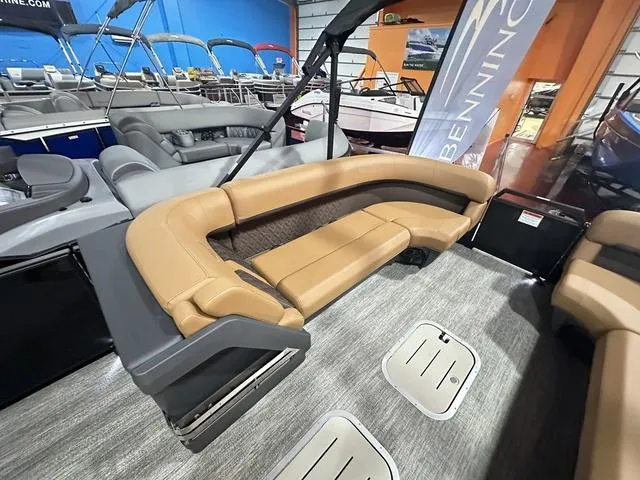 Slide: The Image of 2025 Bennington M Swingback 24 MSB pontoon boat interior with tan seating in showroom. - 8