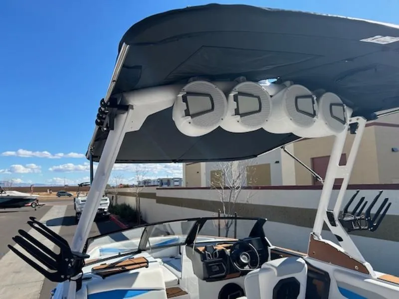 Slide: The Image of 2025 Axis A245 boat with speakers and wakeboard racks under a sunny sky. - 11