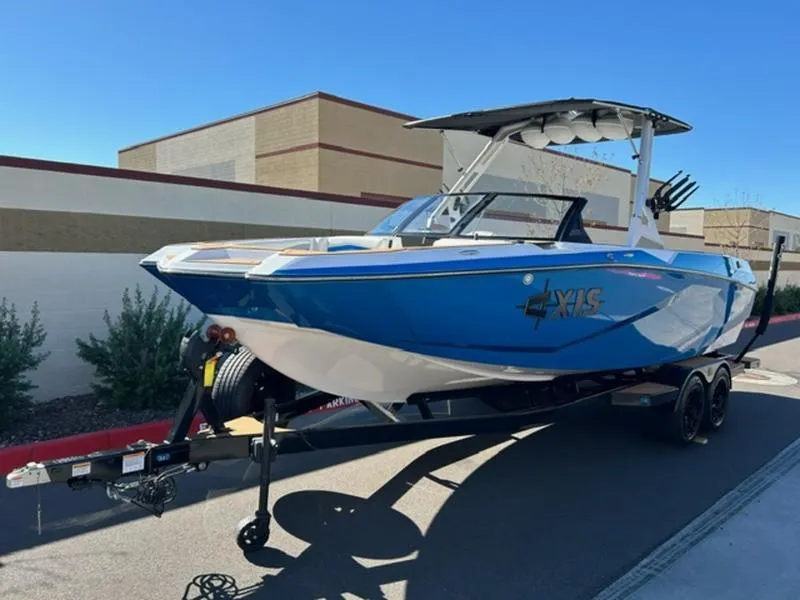 Slide: The Image of 2025 Axis A245 boat on trailer, blue and white design, parked outdoors. - 3