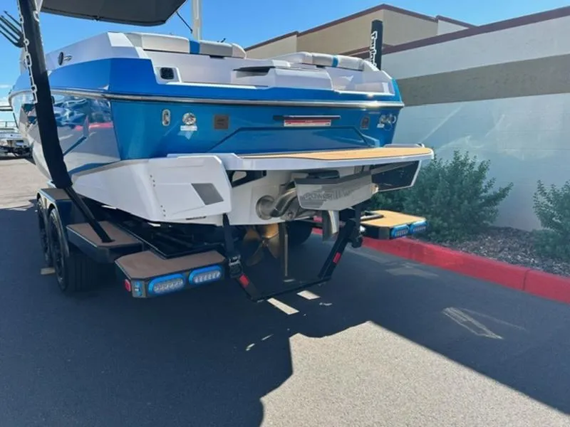 Slide: The Image of 2025 Axis A245 boat on trailer, blue and white, parked outdoors. - 5