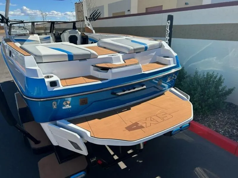Slide: The Image of 2025 Axis A245 boat with blue and white design, docked outdoors. - 6