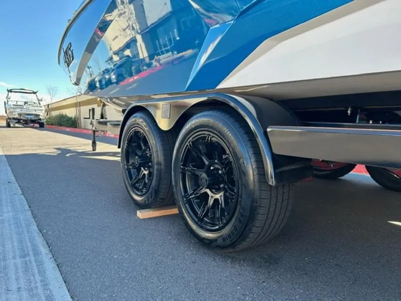 Slide: The Image of 2025 Axis A245 boat trailer with black wheels on a sunny day. - 7