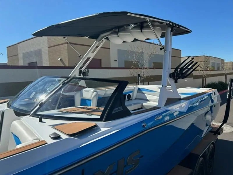Slide: The Image of 2025 Axis A245 boat with blue and white design, featuring a sleek wakeboard tower. - 8