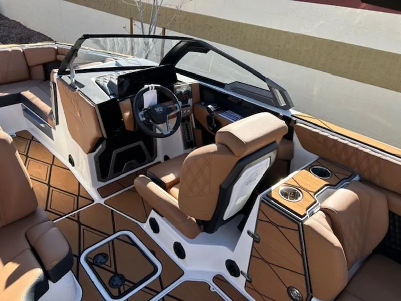 Slide: The Image of 2025 Malibu M242 boat interior with luxurious tan seating and modern dashboard. - 13