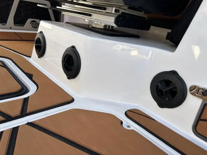 Slide: The Image of 2025 Malibu M242 boat interior with sleek white panel and black speaker vents. - 16