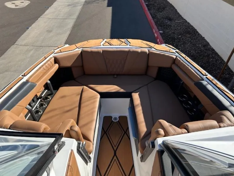 Slide: The Image of 2025 Malibu M242 boat interior with luxurious tan seating and stylish design. - 17