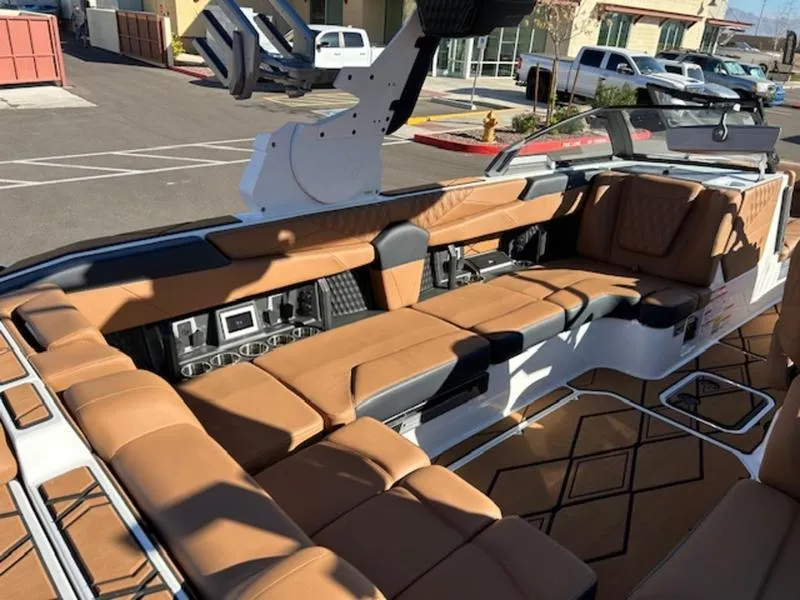 Slide: The Image of 2025 Malibu M242 boat interior with tan leather seating and modern controls. - 18