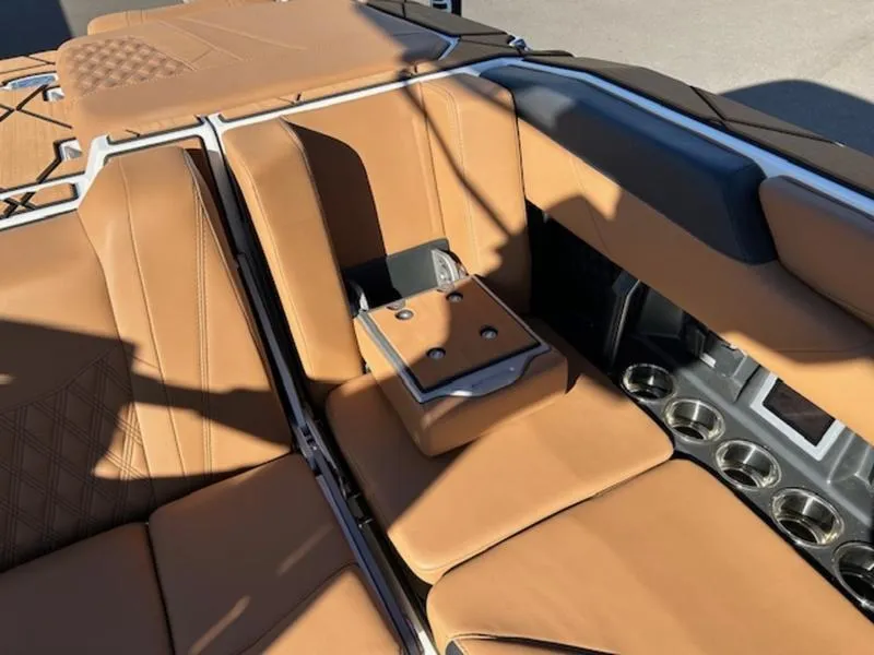 Slide: The Image of 2025 Malibu M242 boat interior with tan leather seats and cup holders. - 25