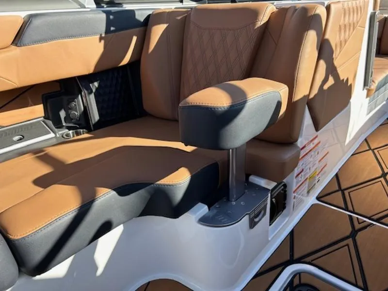 Slide: The Image of 2025 Malibu M242 boat interior with brown leather seating and armrest. - 26