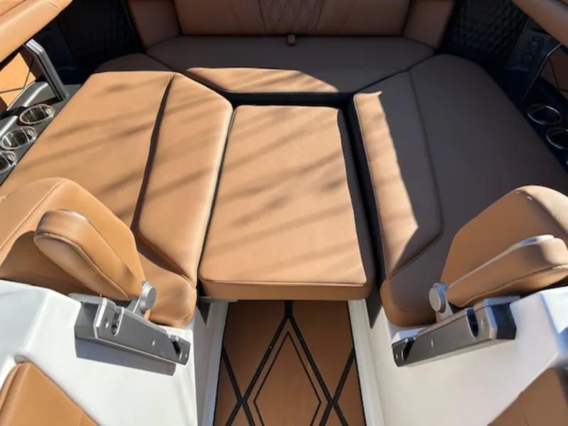Slide: The Image of 2025 Malibu M242 boat interior with tan leather seating and cup holders. - 27