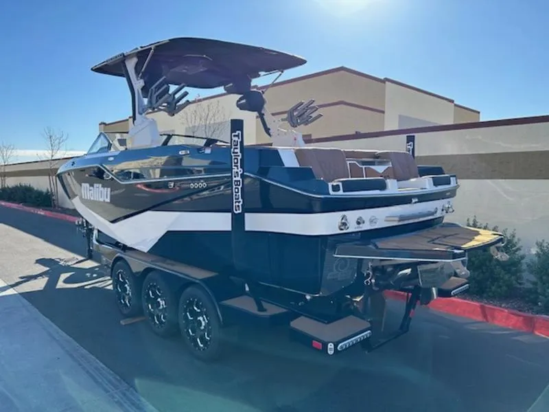 Slide: The Image of 2025 Malibu M242 boat on trailer, sleek design, outdoor setting, sunny day. - 4