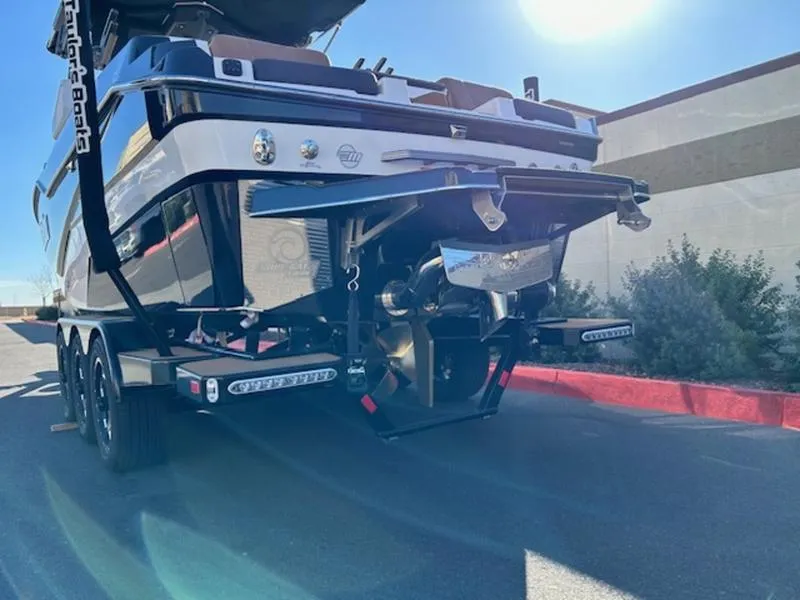 Slide: The Image of 2025 Malibu M242 boat on trailer, rear view, sunny day. - 5