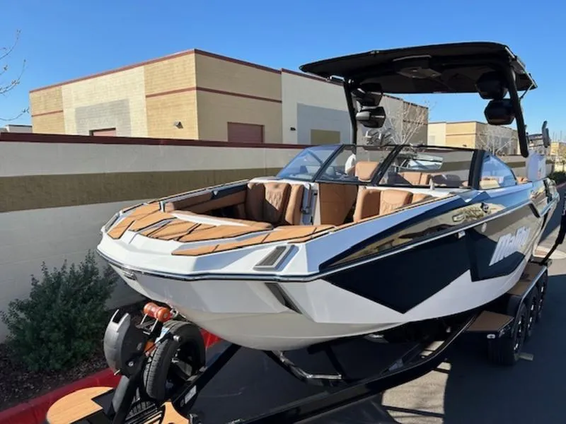 Slide: The Image of 2025 Malibu M242 boat on trailer, sleek design, parked outdoors. - 8