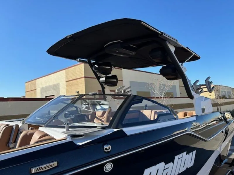 Slide: The Image of 2025 Malibu M242 boat with sleek design and modern features, docked outdoors. - 9