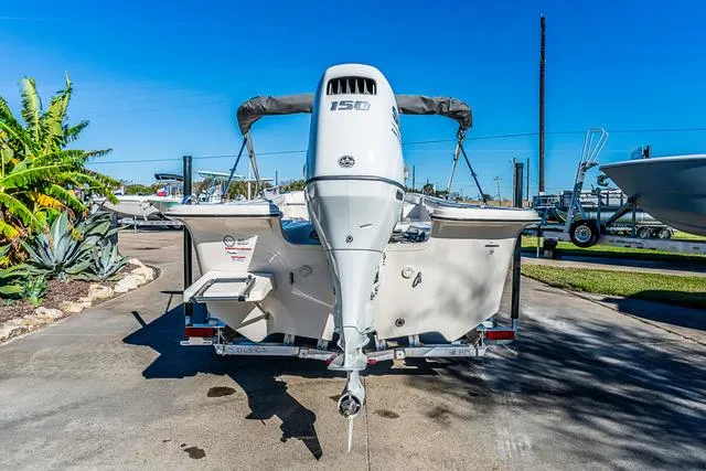 Slide: The Image of 2025 Carolina Skiff 21LS boat with 150 HP engine, parked outdoors. - 11