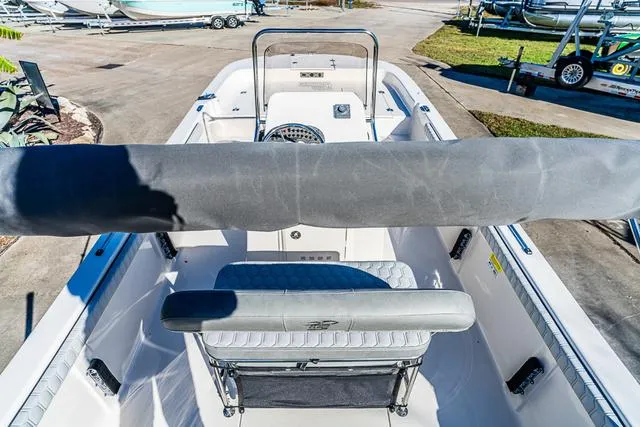 Slide: The Image of 2025 Carolina Skiff 21LS boat interior with seating and console, parked outdoors. - 14