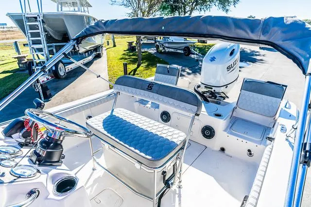 Slide: The Image of 2025 Carolina Skiff 21LS boat interior with seating and Suzuki outboard motor. - 3