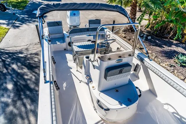 Slide: The Image of 2025 Carolina Skiff 21LS boat interior with seating and console, parked outdoors. - 8