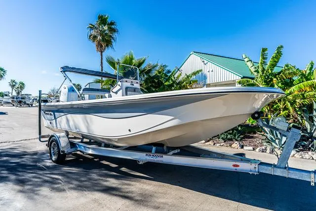 Slide: The Image of 2025 Carolina Skiff 21LS boat on trailer, sunny day, palm trees in background. - 9