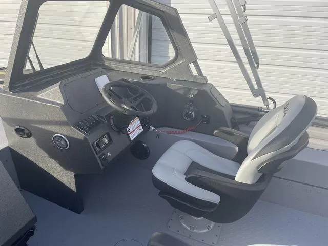 Slide: The Image of 2025 SeaArk Pro Cat 200 boat interior with steering wheel and captain's chair. - 21