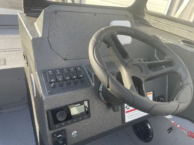 Slide: The Image of 2025 SeaArk Pro Cat 200 boat dashboard with steering wheel and control panel. - 22