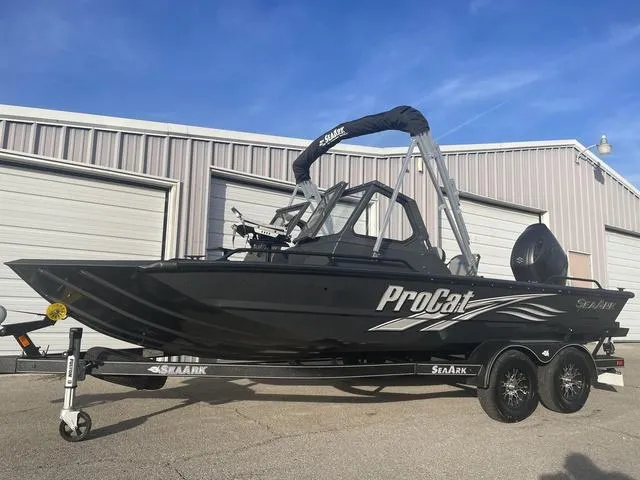Slide: The Image of 2025 SeaArk Pro Cat 200 boat on trailer, parked outside a warehouse. - 6