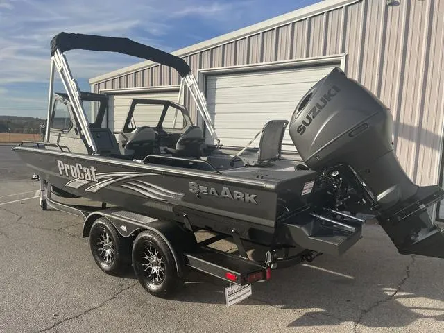 Slide: The Image of 2025 SeaArk Pro Cat 200 boat with Suzuki engine on trailer, parked outside a building. - 7