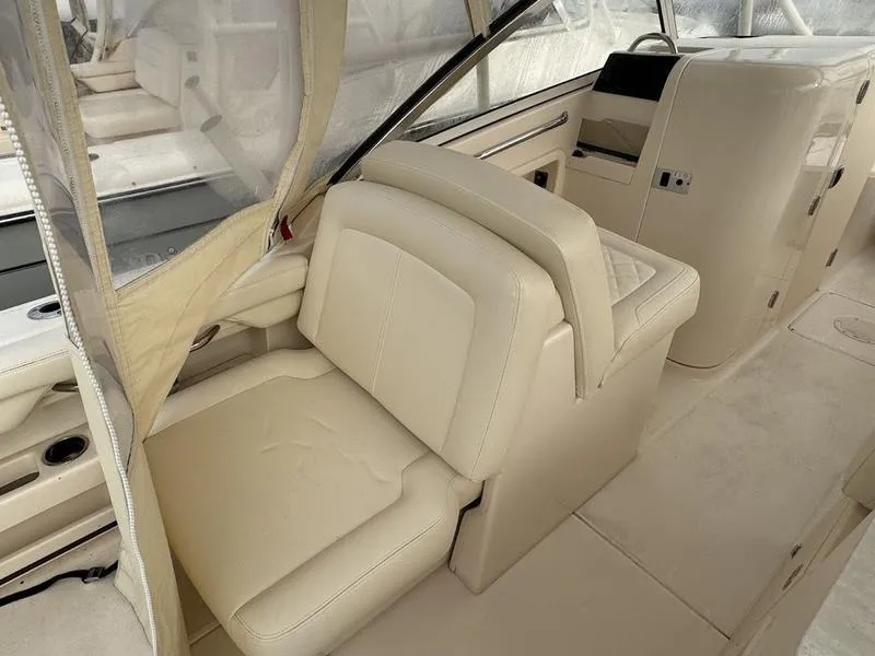 Slide: The Image of 2022 Grady-White 275 Freedom boat interior with beige seating and helm station. - 10