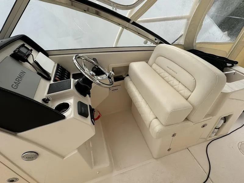 Slide: The Image of 2022 Grady-White 275 Freedom boat interior with Garmin navigation and plush seating. - 13