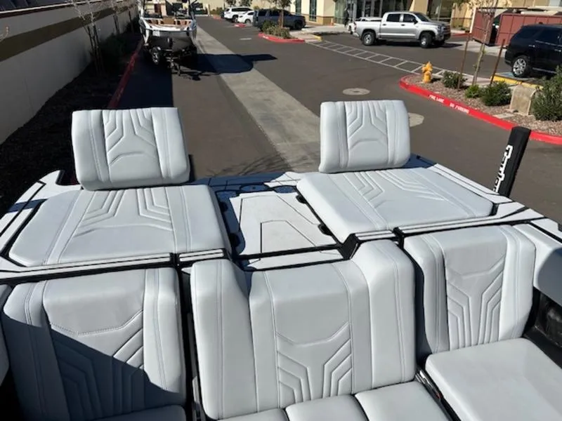 Slide: The Image of 2025 Malibu 25 LSV boat interior with sleek gray seating on a sunny day. - 24