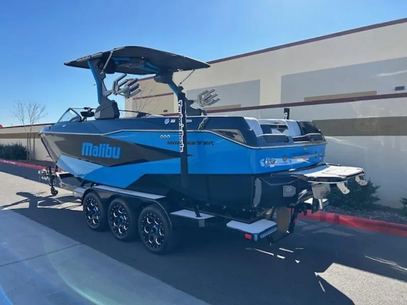 Slide: The Image of 2025 Malibu 25 LSV boat in blue on a trailer, parked outdoors. - 5