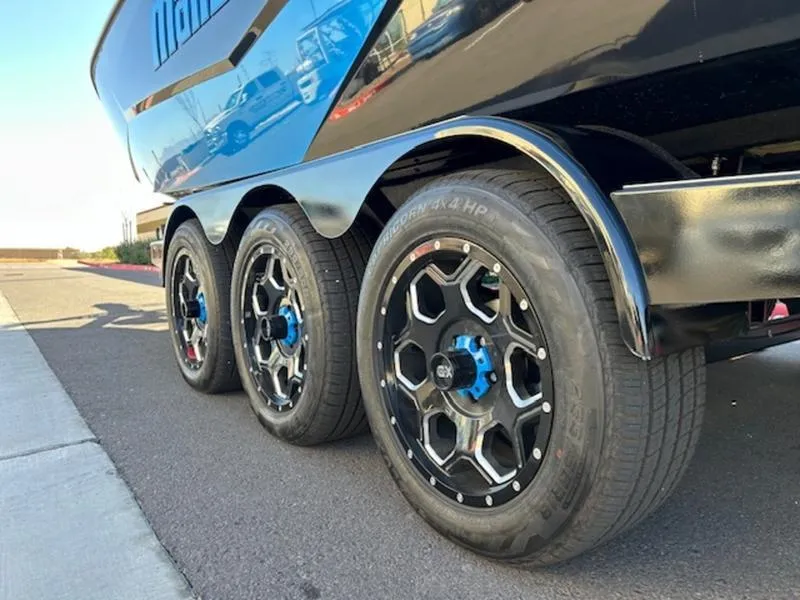 Slide: The Image of 2025 Malibu 25 LSV trailer with triple axle wheels on a sunny day. - 6