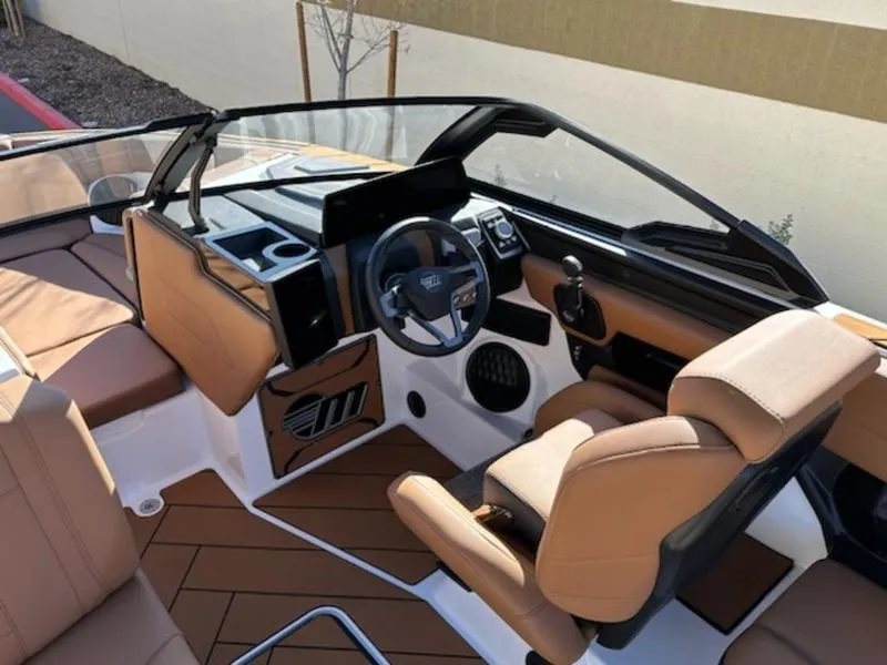 Slide: The Image of 2025 Malibu 22 LSV boat interior with tan seating and modern dashboard. - 14