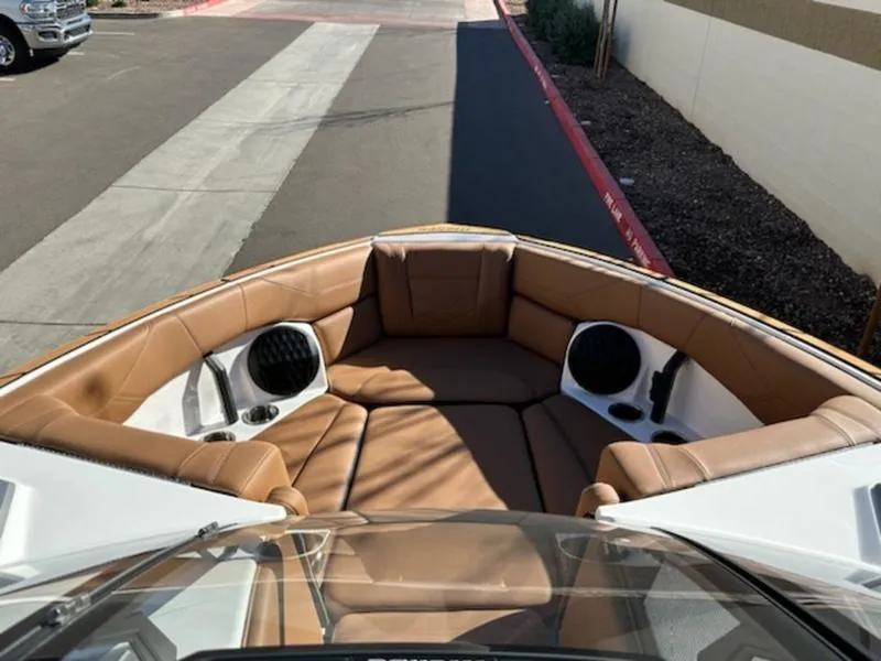 Slide: The Image of 2025 Malibu 22 LSV boat interior with tan leather seating and speakers. - 16