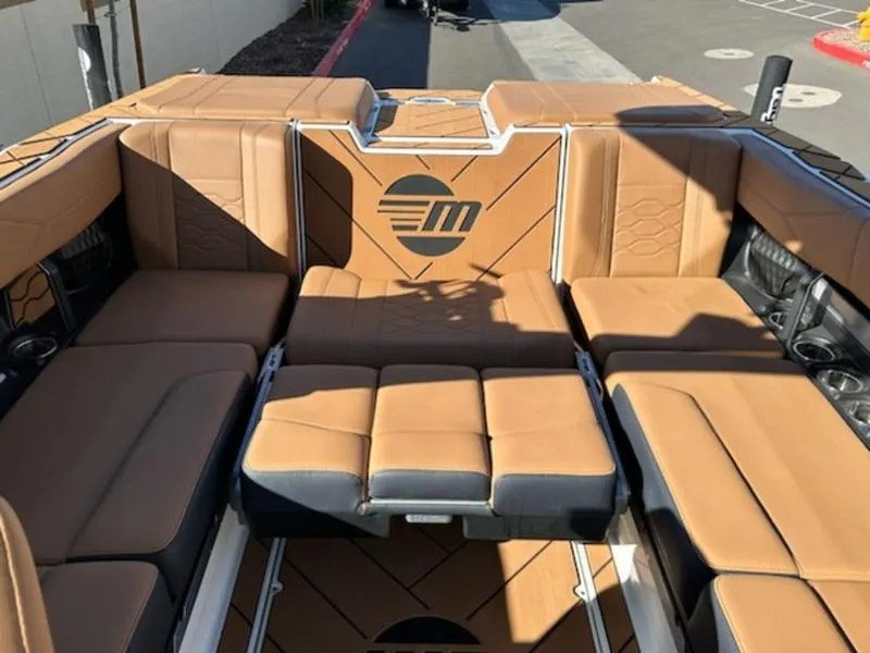 Slide: The Image of 2025 Malibu 22 LSV boat interior with tan leather seating and logo design. - 19