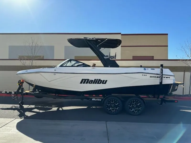 Slide: The Image of 2025 Malibu 22 LSV boat on trailer, parked outdoors, side view. - 3