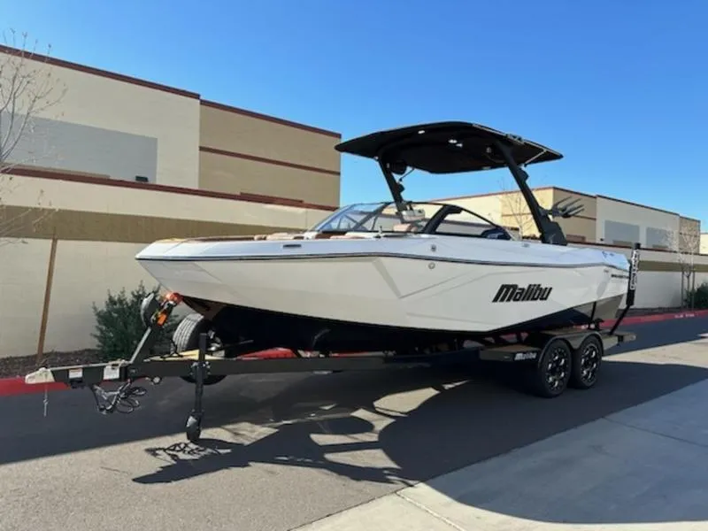 Slide: The Image of 2025 Malibu 22 LSV boat on trailer, parked outdoors. - 4