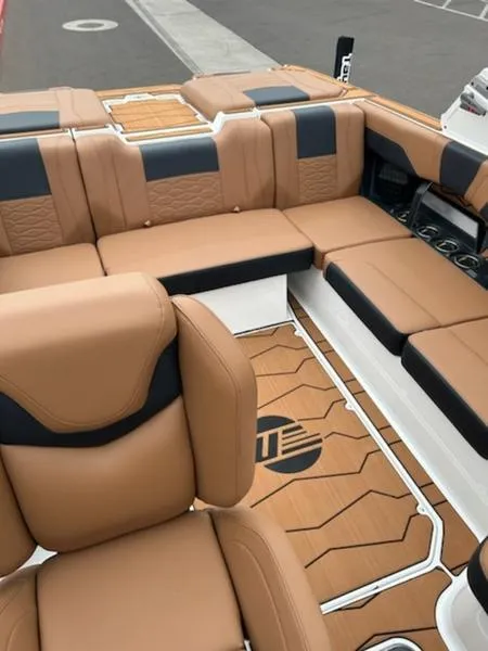 Slide: The Image of 2025 Malibu 22 MXZ boat interior with tan and black seating, stylish design. - 11