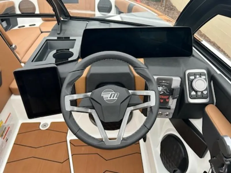 Slide: The Image of 2025 Malibu 22 MXZ boat dashboard with modern steering wheel and digital controls. - 12