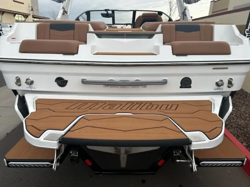 Slide: The Image of 2025 Malibu 22 MXZ boat with brown seating and teak deck. - 13