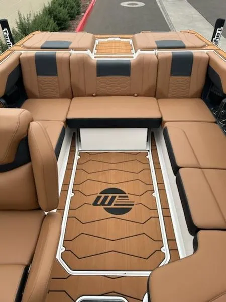 Slide: The Image of 2025 Malibu 22 MXZ boat interior with tan and black seating, stylish flooring design. - 14