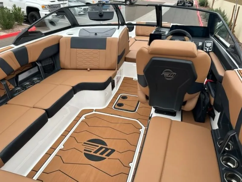Slide: The Image of Luxurious interior of 2025 Malibu 22 MXZ boat with tan and black seating. - 16