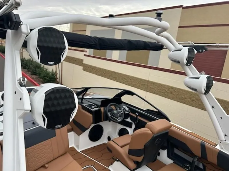 Slide: The Image of 2025 Malibu 22 MXZ boat interior with premium sound system and tan seating. - 19