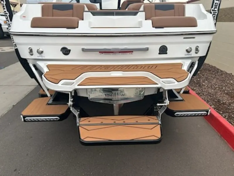 Slide: The Image of 2025 Malibu 22 MXZ boat rear view with teak swim platform and seating. - 4