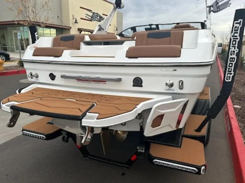 Slide: The Image of 2025 Malibu 22 MXZ boat, rear view, featuring brown seating and swim platform. - 8