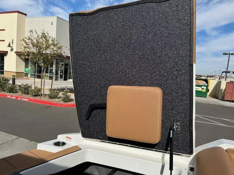 Slide: The Image of 2024 Axis T235 boat interior with open storage compartment in a parking lot. - 13