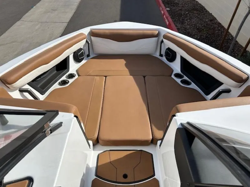 Slide: The Image of 2024 Axis T235 boat interior with tan and white seating, cup holders, and speakers. - 18