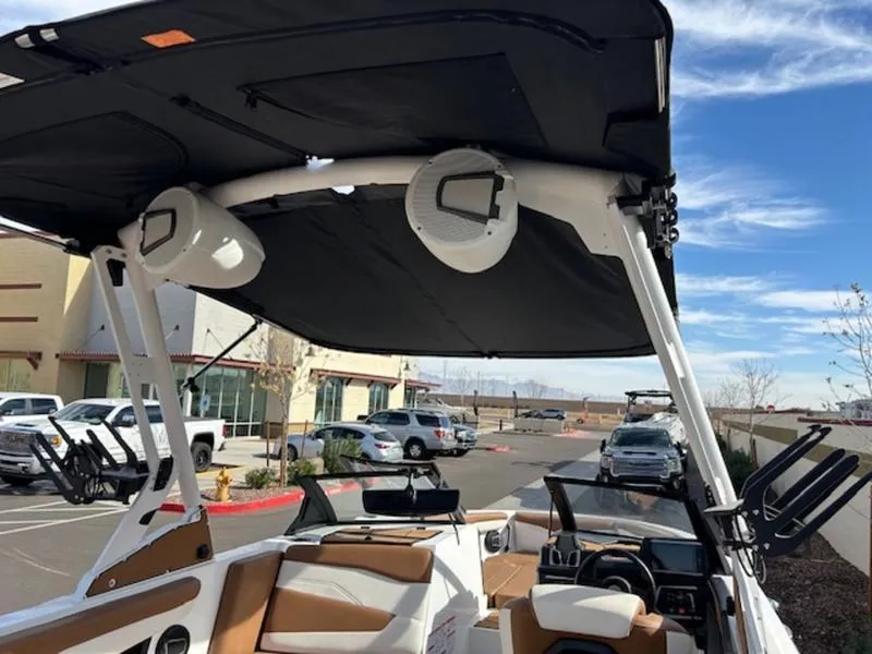 Slide: The Image of 2024 Axis T235 boat interior with speakers and seating, parked outdoors. - 22